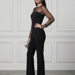 Black Oksana sheer fitted bodice flared leg jumpsuit by THE WHITMORE FAMILY, featuring a sleek silhouette and elegant design.