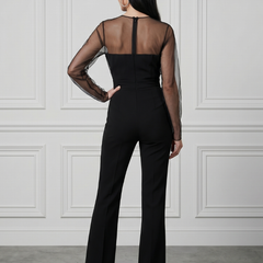 Black Oksana sheer fitted bodice flared leg jumpsuit by THE WHITMORE FAMILY, shown on a model with elegant design details.