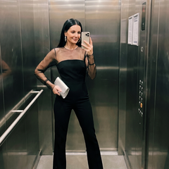 Black Oksana sheer fitted bodice flared leg jumpsuit by THE WHITMORE FAMILY, showing a close-up of the stylish design and fabric details.