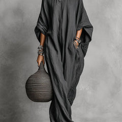 Black Serena oversized maxi dress by THE WHITMORE FAMILY, flowing fabric and relaxed fit, displayed hanging.