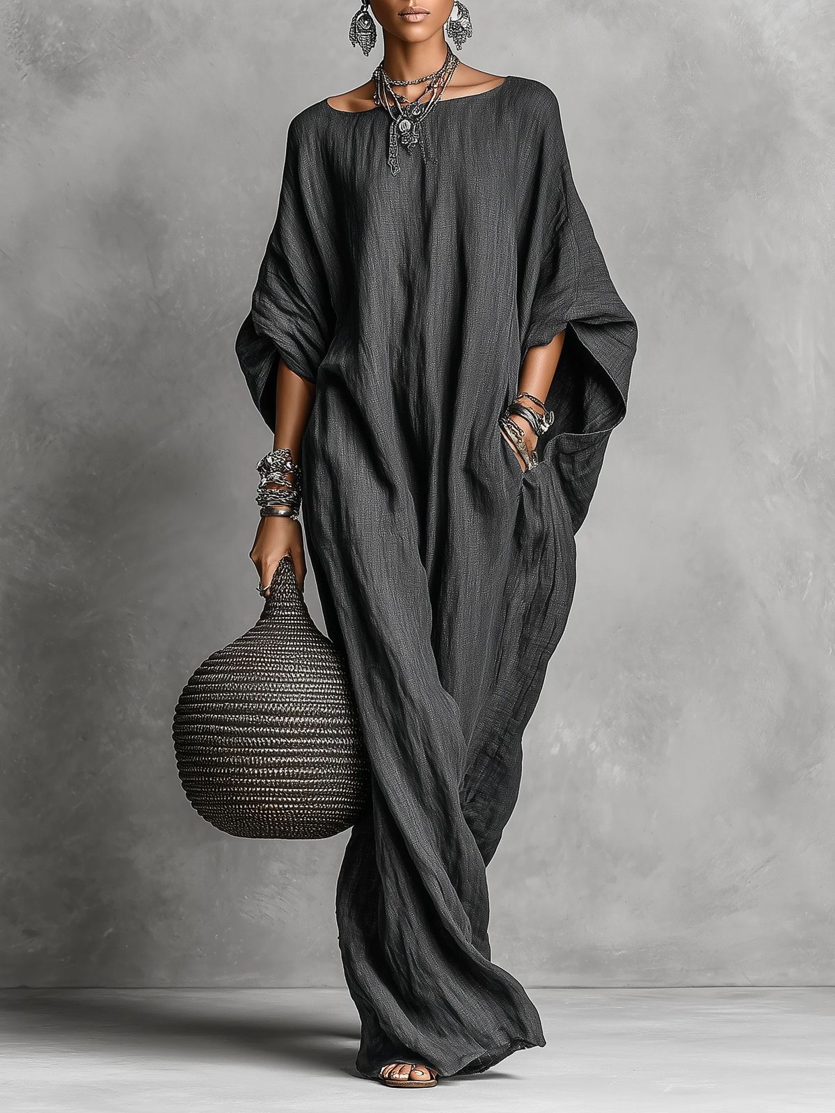 Black Serena oversized maxi dress by THE WHITMORE FAMILY, flowing fabric and relaxed fit, displayed hanging.