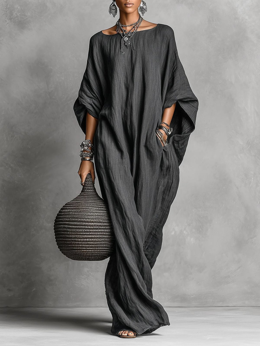 Black Serena oversized maxi dress by THE WHITMORE FAMILY, flowing fabric and relaxed fit, displayed hanging.