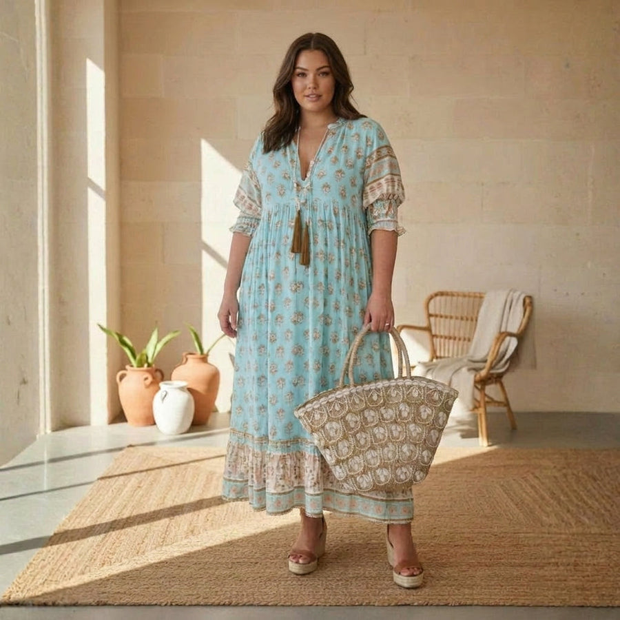 Bohemian style dress by THE WHITMORE FAMILY, featuring flowing fabric and intricate patterns, displayed on a hanger.