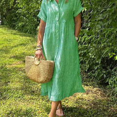 Blue Angela maxi dress by THE WHITMORE FAMILY, flowing fabric and elegant design, displayed on a hanger.