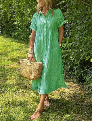 Blue Angela maxi dress by THE WHITMORE FAMILY, flowing fabric and elegant design, displayed on a hanger.