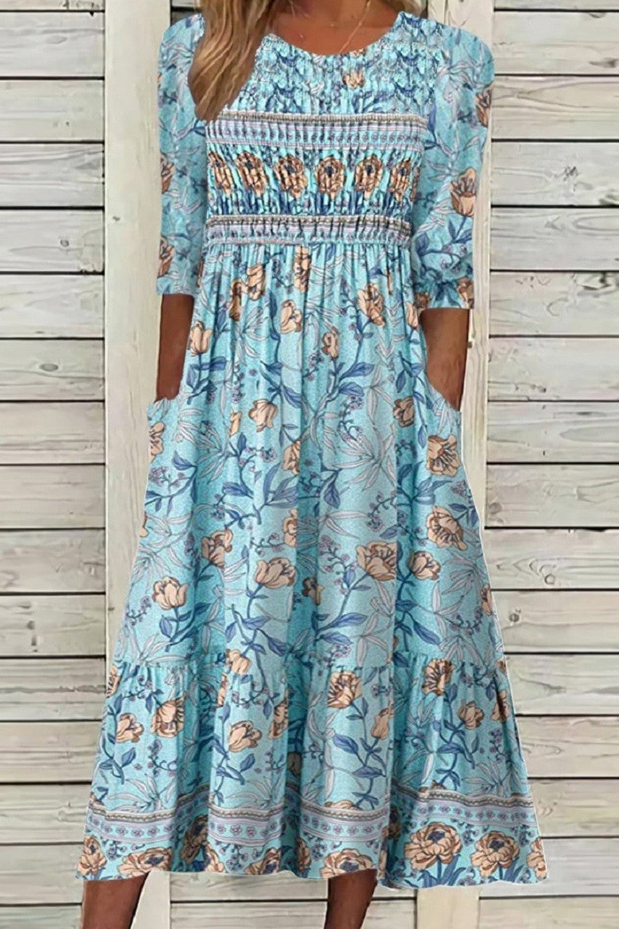 Blue Aphra Petal Muse Dress by THE WHITMORE FAMILY, displayed on a hanger with floral petal details and elegant fabric.