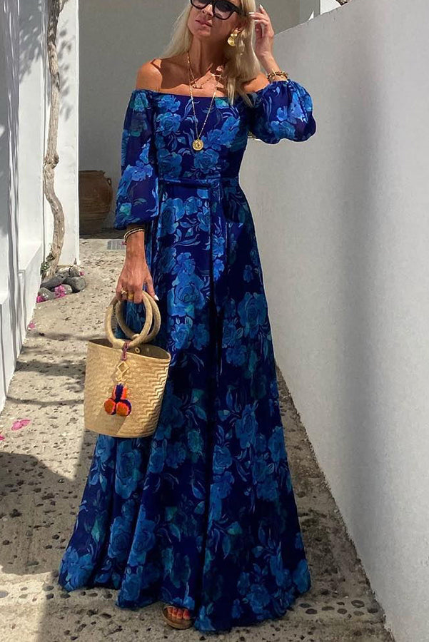 Blue Francesca long floral print dress by THE WHITMORE FAMILY, featuring a flowing silhouette and vibrant floral pattern.