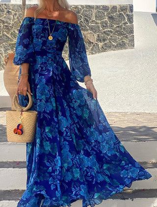 Blue Francesca long dress with floral print by THE WHITMORE FAMILY, featuring a flowing silhouette and vibrant flower patterns.