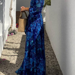 Blue Francesca long floral print dress by THE WHITMORE FAMILY, flowing fabric with vibrant flower patterns.
