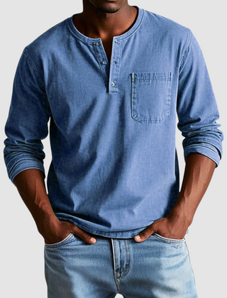 Blue Harrison™ Vintage Henley Shirt by THE WHITMORE FAMILY displayed on a hanger, showcasing its classic button-up style and fabric texture.