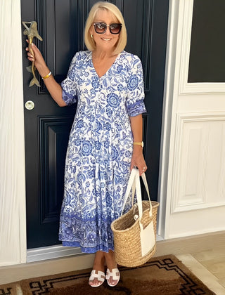 Blue Keisha floral V-neck dress by THE WHITMORE FAMILY, featuring a graceful design and vibrant floral pattern.