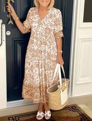 Blue Keisha floral V-neck dress by THE WHITMORE FAMILY, featuring a graceful design with vibrant floral patterns.