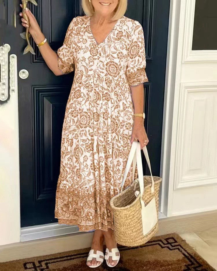 Blue Keisha floral V-neck dress by THE WHITMORE FAMILY, featuring a graceful design with vibrant floral patterns.