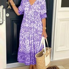 Blue Keisha Graceful V-Neck Floral dress by THE WHITMORE FAMILY, showcasing a floral pattern and elegant V-neck design.