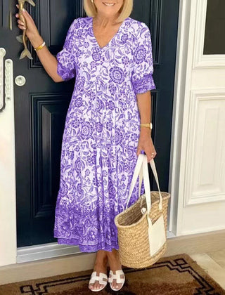 Blue Keisha Graceful V-Neck Floral dress by THE WHITMORE FAMILY, showcasing a floral pattern and elegant V-neck design.
