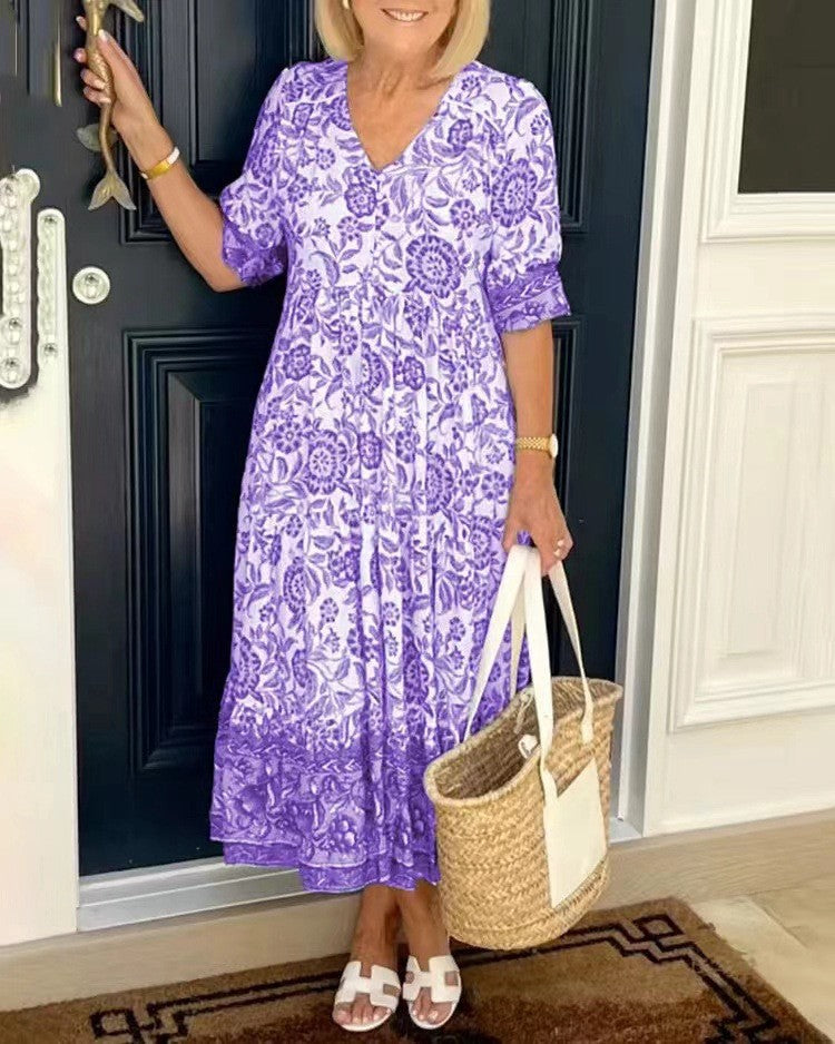 Blue Keisha Graceful V-Neck Floral dress by THE WHITMORE FAMILY, showcasing a floral pattern and elegant V-neck design.