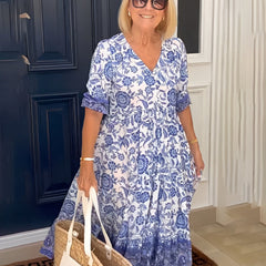 Blue Keisha Graceful V-Neck Floral dress by THE WHITMORE FAMILY, featuring a floral pattern and elegant V-neck design.