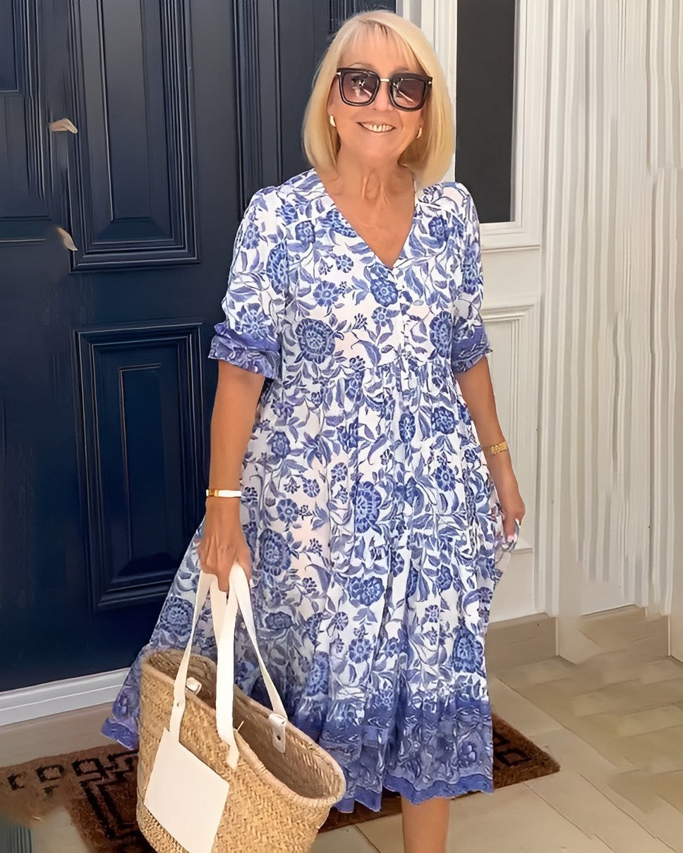 Blue Keisha Graceful V-Neck Floral dress by THE WHITMORE FAMILY, featuring a floral pattern and elegant V-neck design.