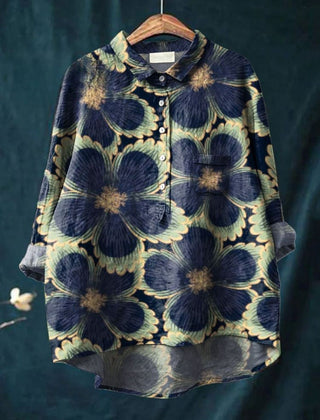 Sophia floral bloom shirt by THE WHITMORE FAMILY, featuring a blue fabric with vibrant floral patterns.