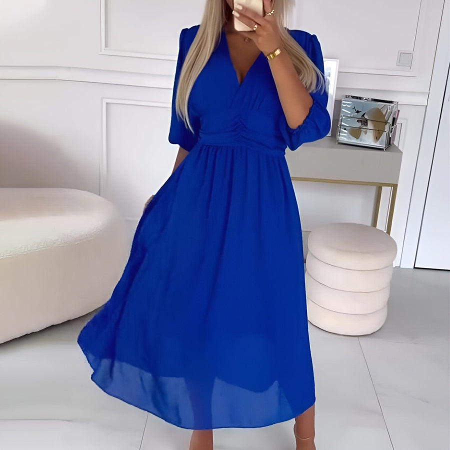Blue Sophie elegant wrap dress by THE WHITMORE FAMILY, featuring a flattering fit and stylish design, displayed on a mannequin.