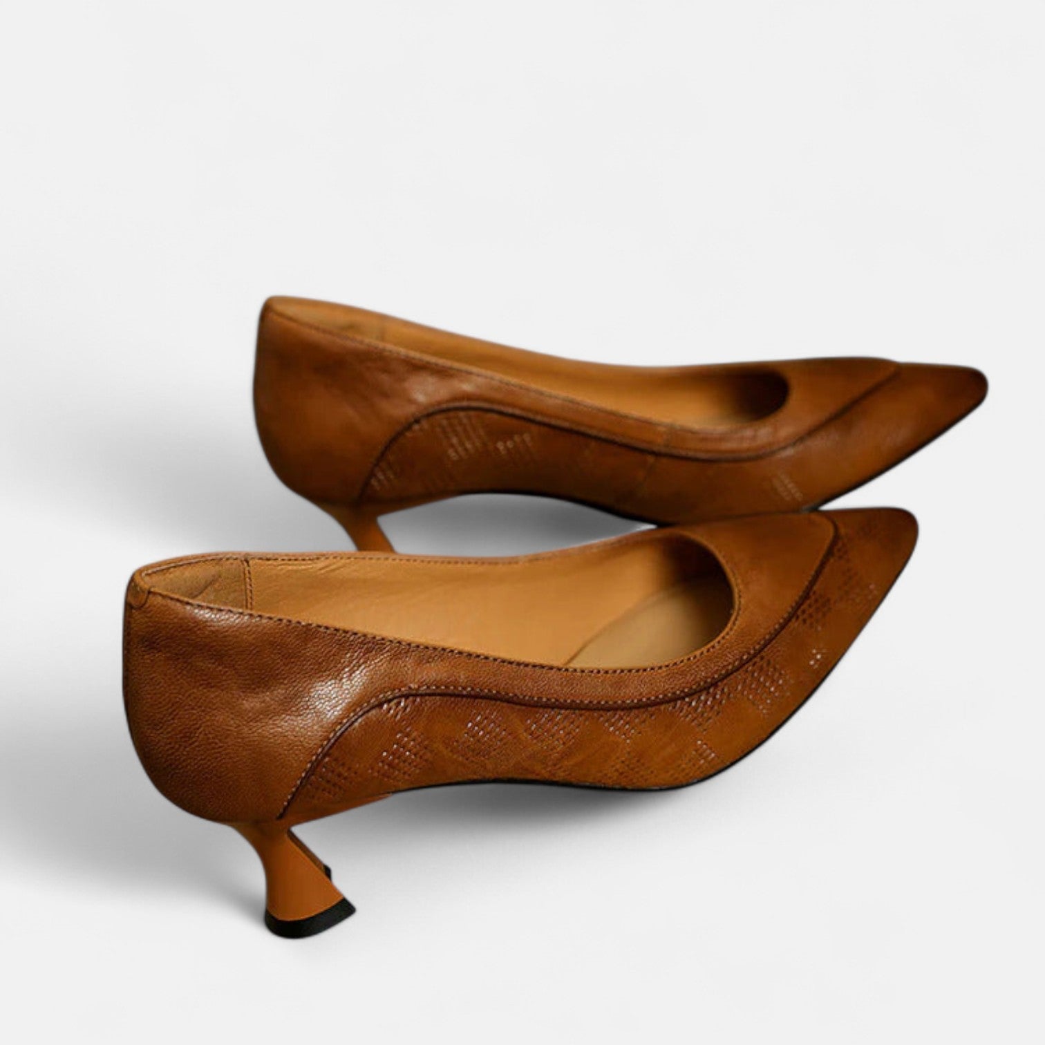 Brown leather heels from THE WHITMORE FAMILY's Amara collection, featuring elegant pointed toes and stylish ankle straps.