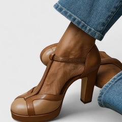 Brown Seliora sophisticated heels by THE WHITMORE FAMILY, featuring elegant design and pointed toe on a neutral background.
