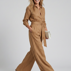 Brown Jovie long sleeve button-front wide-leg jumpsuit by THE WHITMORE FAMILY, displayed on a hanger.