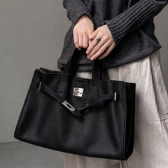 Black leather tote bag from THE WHITMORE FAMILY's Meridian collection, shown on a model, showcasing stylish and spacious design.