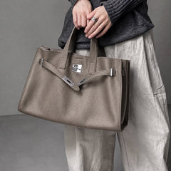 Taupe leather tote bag from The Meridian collection by THE WHITMORE FAMILY, displayed on a model.