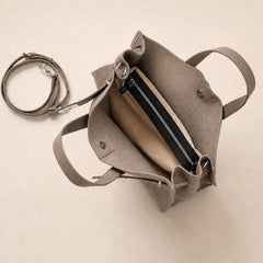 Taupe leather tote bag with interior compartments, crafted by THE WHITMORE FAMILY, showcasing its spacious design and quality craftsmanship.