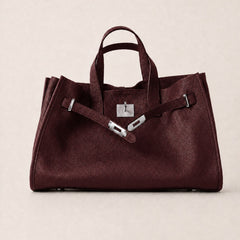 Burgundy leather tote bag by THE WHITMORE FAMILY, The Meridian Leather Tote, featuring sleek design and sturdy handles.