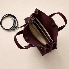 Interior view of The Meridian Leather Tote by THE WHITMORE FAMILY, showcasing burgundy leather lining and spacious design.