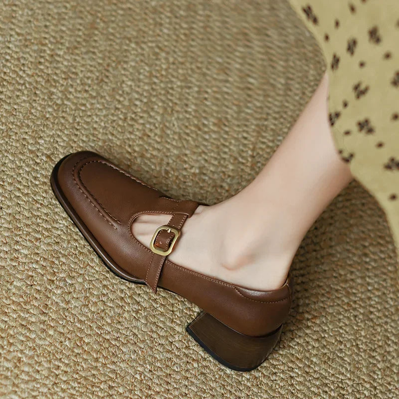 Black Ysolenne Classic Stylish T-Strap Pumps by THE WHITMORE FAMILY, showcasing elegant design and sleek T-strap detailing.