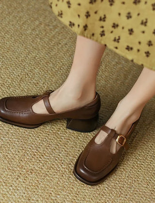 Black Ysolenne T-strap pumps by THE WHITMORE FAMILY, stylish classic footwear with a sleek T-strap design and comfortable heel.