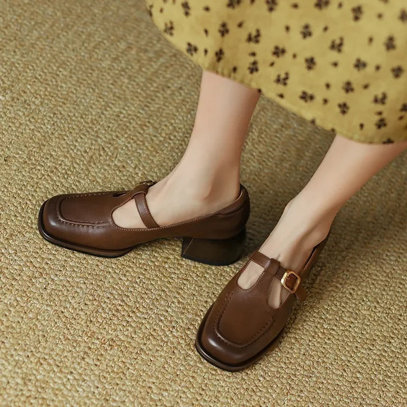 Black Ysolenne T-strap pumps by THE WHITMORE FAMILY, stylish classic footwear with a sleek T-strap design and comfortable heel.