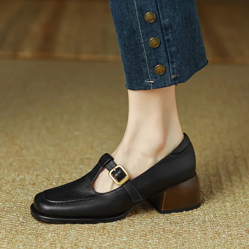 Black Ysolenne T-strap pumps by THE WHITMORE FAMILY, classic stylish design, with a sleek T-strap and comfortable heel.