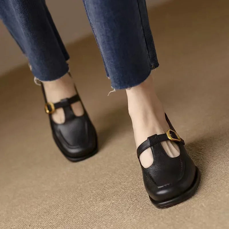 Black Ysolenne Classic Stylish T-Strap Pumps by THE WHITMORE FAMILY, featuring elegant T-strap design and sleek silhouette.
