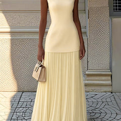 Cream Serena pleated maxi dress by THE WHITMORE FAMILY, flowing fabric with elegant pleats, full-length gown on a model.