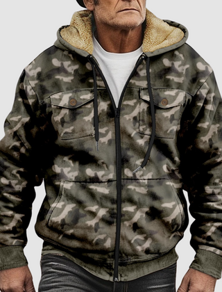 Sam™ camouflage jacket by THE WHITMORE FAMILY displayed on a hanger, featuring a green and brown woodland camo pattern.