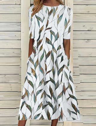 An Annie Coastal Bloom Dress by THE WHITMORE FAMILY, featuring a blue floral pattern, displayed flat on a white background.