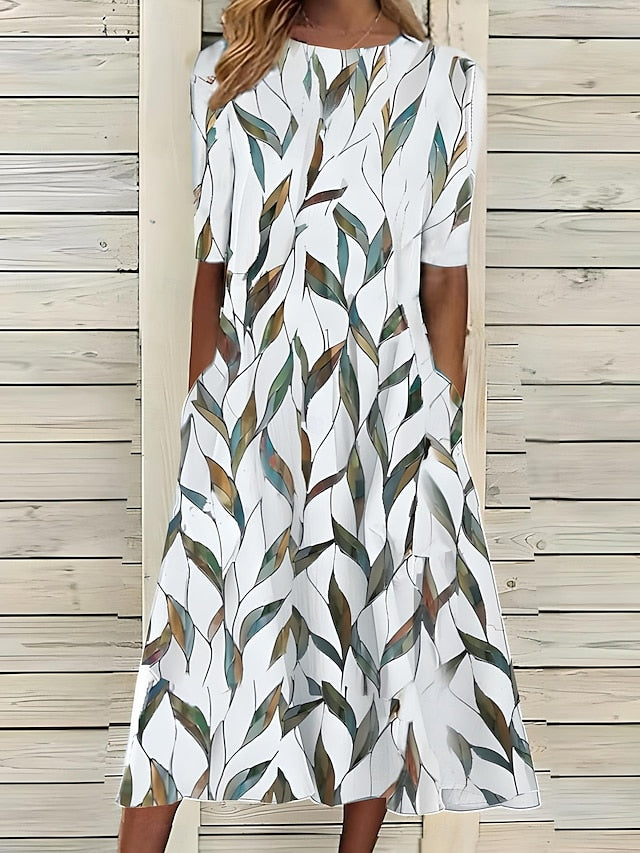 An Annie Coastal Bloom Dress by THE WHITMORE FAMILY, featuring a blue floral pattern, displayed flat on a white background.