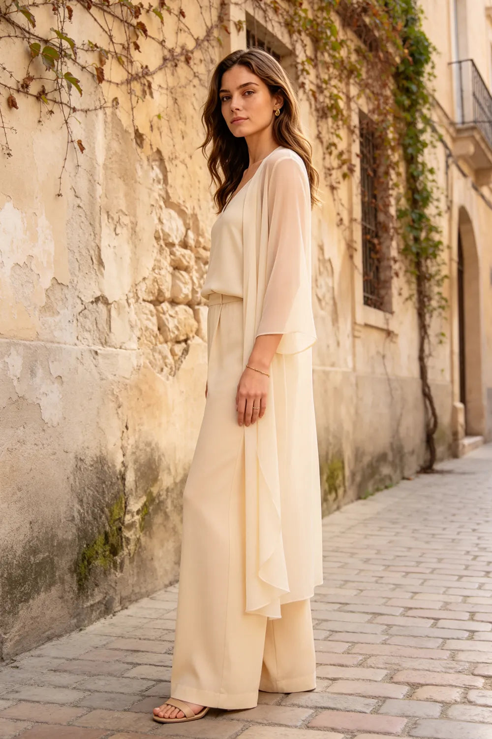 Elegant champagne dress by THE WHITMORE FAMILY featuring a refined camisole, chiffon jacket, and matching pants.