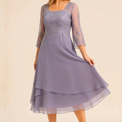 Embroidered chiffon mother of the bride dress by THE WHITMORE FAMILY, featuring elegant floral embroidery and a flowing silhouette.