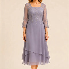 Embroidered chiffon mother of the bride dress by THE WHITMORE FAMILY, featuring elegant embroidery and flowing fabric.