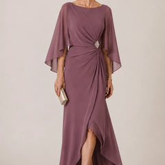 Dark navy chiffon dress by THE WHITMORE FAMILY featuring cape sleeves, wrap design, and a decorative brooch.