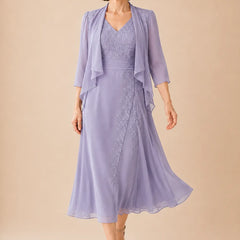 Lilac V-neck chiffon midi dress with lace details by THE WHITMORE FAMILY, featuring elegant flowing fabric and feminine design.