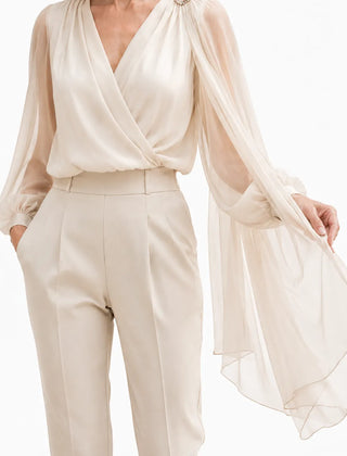 Elegant champagne chiffon cape blouse by THE WHITMORE FAMILY, featuring flowing fabric and delicate design for wedding guest attire.