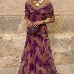 Hendrika Coral Glow evening dress by THE WHITMORE FAMILY featuring vibrant coral color and elegant design in a garden setting