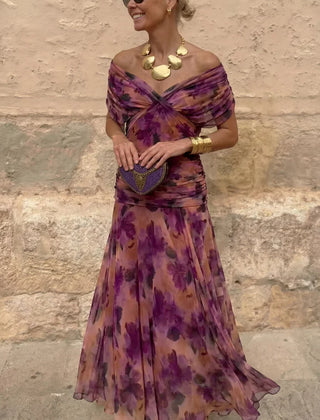 Hendrika Coral Glow evening dress by THE WHITMORE FAMILY featuring vibrant coral color and elegant design in a garden setting