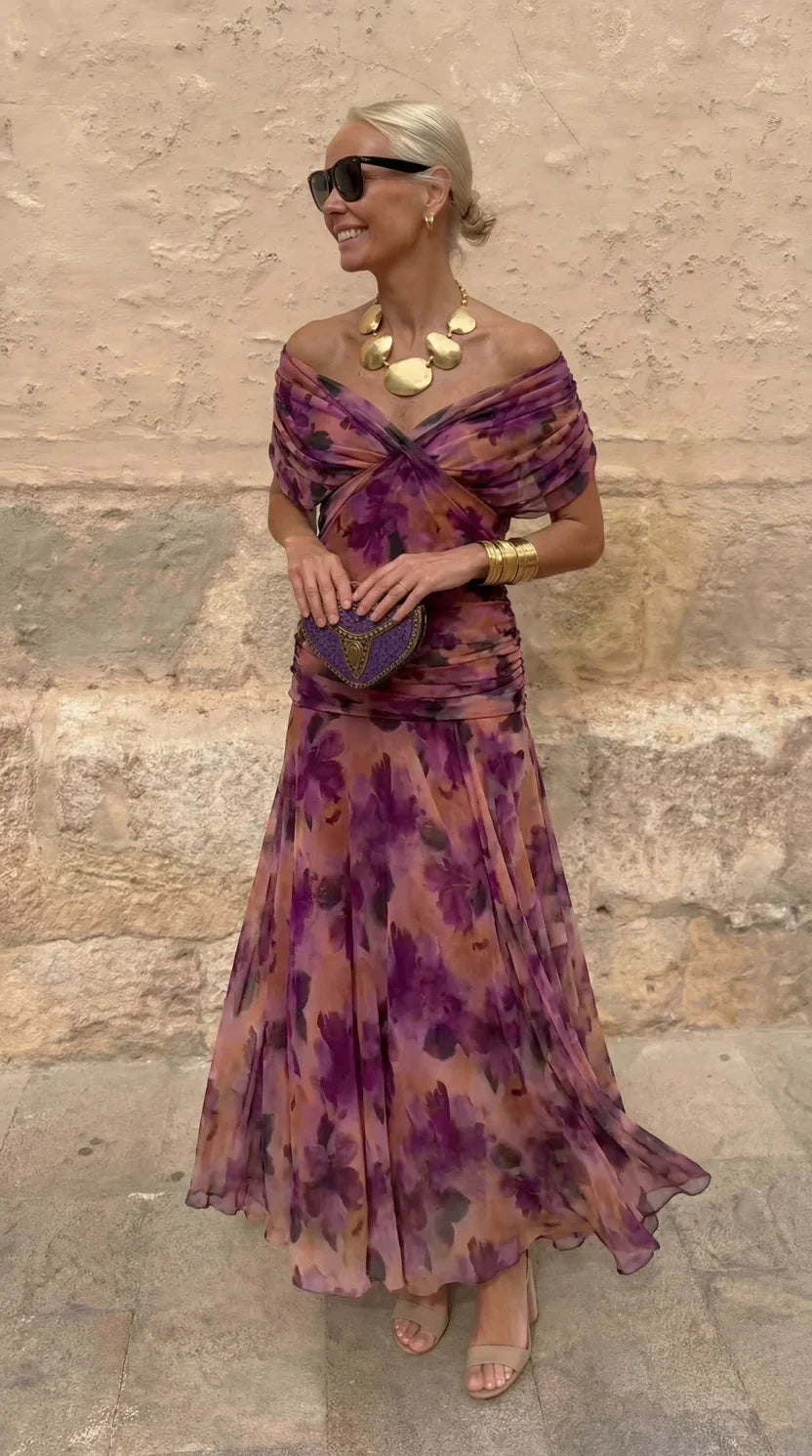 Hendrika Coral Glow evening dress by THE WHITMORE FAMILY featuring vibrant coral color and elegant design in a garden setting